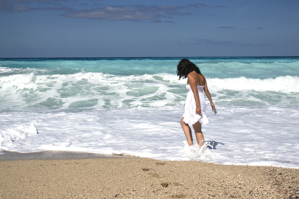 woman wading in water on beach